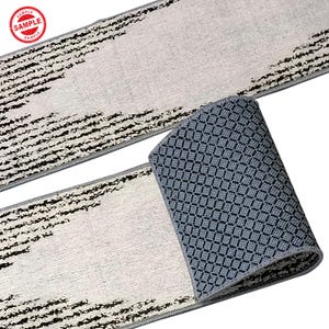 Puede incluir: Un tapete de corredor blanco y negro con un respaldo antideslizante gris. El tapete tiene un dise&ntilde;o moderno con l&iacute;neas negras y un fondo blanco.