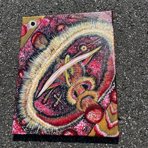 May include: Abstract painting on canvas with a red, white, and gold color scheme. The painting features a central, swirling, white shape with a gold line extending from it. The background is a dark red with white and gold accents.