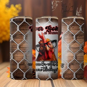 Könnte beinhalten: Ein weißer Becher mit braunem Holzmaserungsmuster und weißem Drahtzaunmuster. Der Becher zeigt einen roten Hahn mit Brille und den Text "Ever look at someone and wonder what they were thinking?"