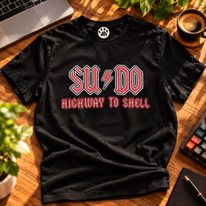 May include: A black short-sleeve t-shirt featuring a red and white graphic print on the chest. The text reads SU DO with a lightning bolt in the center, and the words HIGHWAY TO SHELL printed below in a matching font style.