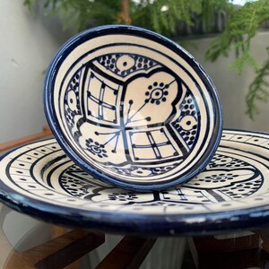Peut inclure: Un ensemble de deux assiettes en céramique bleu et blanc avec des motifs floraux complexes. La plus petite assiette est empilée sur la plus grande.