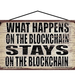 K&ouml;nnte beinhalten: Ein rustikales Holzschild mit einem abgenutzten wei&szlig;en Hintergrund und schwarzem Text, der "Was auf der Blockchain passiert, bleibt auf der Blockchain" lautet.
