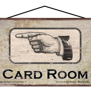 May include: A rectangular wooden sign with a distressed finish. The sign features a black and white illustration of a hand pointing to the right, with the words "CARD ROOM" in bold black letters. The sign is designed for a card room.