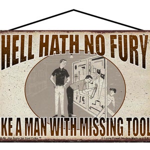 May include: Vintage-style metal sign with the text "HELL HATH NO FURY LIKE A MAN WITH MISSING TOOLS." The sign features a retro illustration of men in a workshop. The sign is rectangular with a black hanging wire.