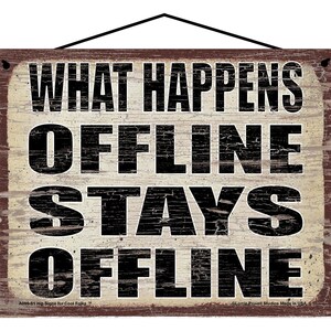 May include: A rustic wooden sign with a distressed white background and black text that reads "WHAT HAPPENS OFFLINE STAYS OFFLINE". The sign has a brown border and a hole at the top for hanging.