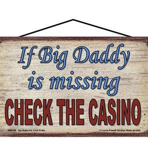May include: Wooden sign with the text "If Big Daddy is missing CHECK THE CASINO" in blue and red lettering. The sign has a distressed, vintage look with a black hanging cord.