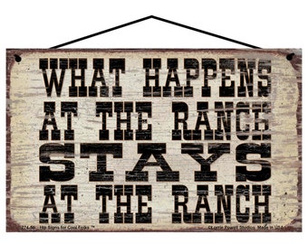May include: A rustic wooden sign with a distressed white background and black lettering. The sign reads "What Happens at the Ranch Stays at the Ranch".