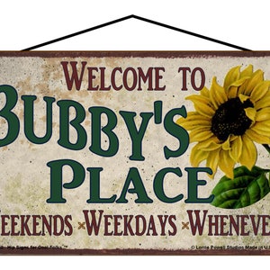 May include: A rustic-style metal sign with a sunflower design. The sign reads "Welcome to Bubby's Place" and "Weekends Weekdays Whenever".