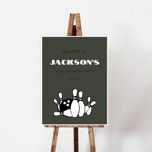 May include: A green welcome sign with white text that reads "Welcome to Jackson's 12th Birthday Party 04.18.XX". The sign features a black and white illustration of bowling pins and a bowling ball.