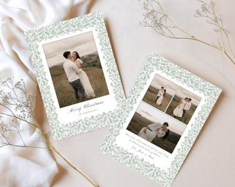 May include: Two Christmas cards with photos of a couple, framed by a green leaf border. One card says "Merry Christmas" and the other has a longer message. The cards are on a white surface with sprigs of dried flowers.