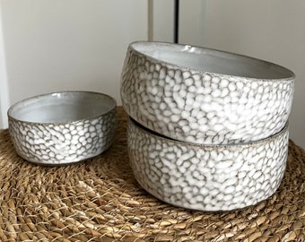 various handmade bowls in white with a dotted ceramic pattern