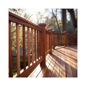 May include: A wooden deck railing with a curved design. The railing is made of dark brown wood and has vertical slats. The deck is made of light brown wood and is in the shade.