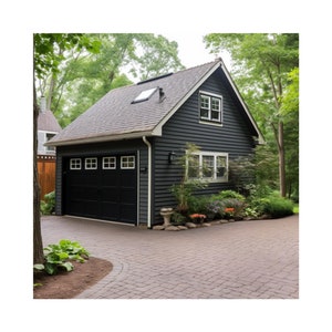 May include: A black garage with a white door and windows. The garage has a gray roof and a small dormer window. The garage is surrounded by green trees and bushes.
