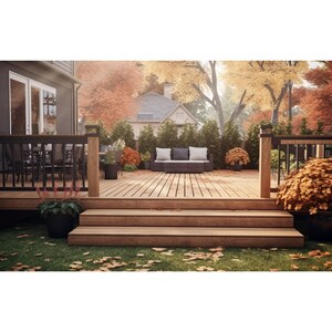 May include: A wooden deck with steps leading down to a grassy area. The deck has a black railing and a seating area with a couch and pillows. There are trees and bushes in the background, with fall foliage in shades of red, orange, and yellow.