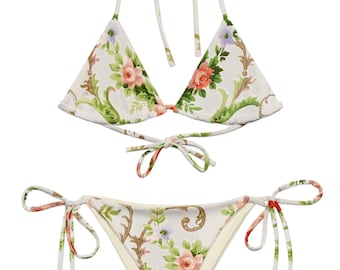 May include: A white bikini with a floral print. The top is a triangle style with adjustable straps and ties at the back. The bottom is a cheeky style with ties on the sides.