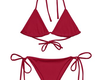 Op de afbeelding: Een rode bikini met een driehoekige top en een zijkant met strik.