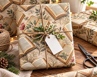 May include: A rectangular gift box wrapped in beige paper featuring a vintage-style pattern of open books, green leaves, and small flowers. The package is tied with brown twine, adorned with a sprig of greenery, and includes a blank white gift tag.