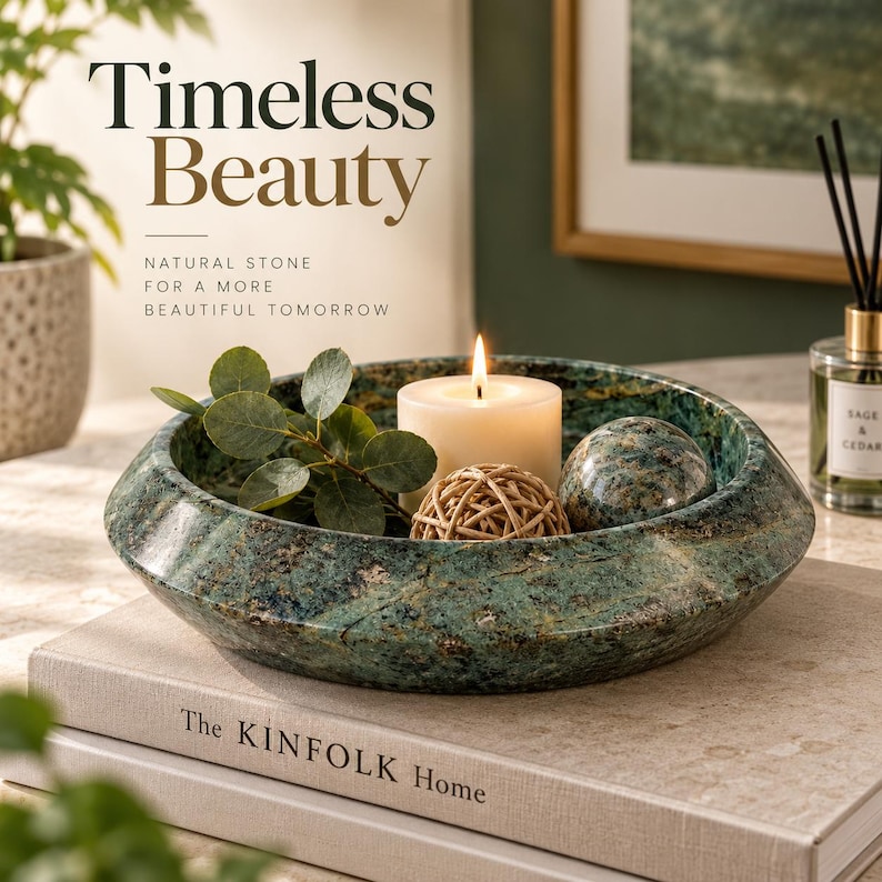 May include: A round, green, mottled natural stone bowl containing a white pillar candle, a small woven rattan sphere, a smooth stone sphere, and a sprig of green leaves. The text "Timeless Beauty" and "Natural stone for a more beautiful tomorrow" is visible.