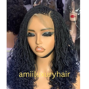 May include: Black braided wig with a lace front. The wig is styled in a curly, loose braid pattern. The wig is on a mannequin head.