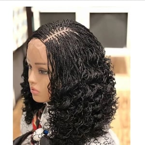 May include: A black braided wig with curly ends. The wig is made with small braids and has a lace front.
