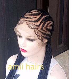 May include: A black braided wig with a lace front and two long braids. The wig is on a mannequin head. The text "ami hairs" is visible in the image.