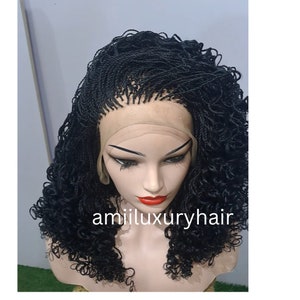 Może przedstawiać: Czarna peruka warkoczowa z kręconymi końcówkami, ułożona w stylu pół-góra, pół-dół. Peruka wykonana jest z koronki z przodu i jest przeznaczona do noszenia na głowie manekina. Peruka jest oznaczona jako "amii luxury hair".