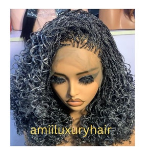 May include: A black and gray braided wig with curly ends. The wig is styled in a half-up, half-down style with the braids pulled back and the curls cascading down the sides. The wig is made with human hair and is available in a variety of lengths and colors.