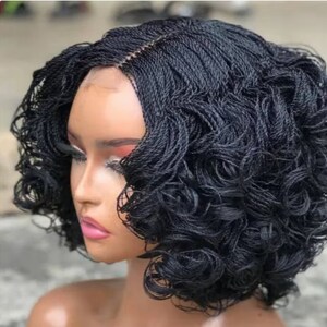 May include: A black wig with a curly bob style, made with braided hair. The wig has a lace front and is styled in a way that resembles a natural hairstyle.