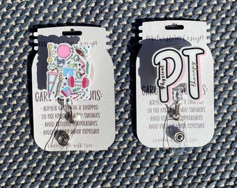Puede incluir: Dos etiquetas rectangulares de cartulina blanca con esquinas redondeadas. Cada etiqueta tiene un fondo blanco con texto negro y un gráfico colorido. La etiqueta de la izquierda tiene un gráfico de una mancuerna rosa, una esterilla de yoga azul, una pelota de ejercicio verde y amarilla, un bastón rosa y blanco y otros artículos relacionados con el fitness. La etiqueta de la derecha tiene un gráfico de las letras "PT" en rosa y blanco con las palabras "Fisioterapia" escritas en negro. Ambas etiquetas tienen un carrete de insignia retráctil plateado unido a ellas.