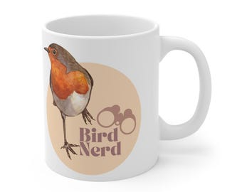 May include: White ceramic mug with a brown robin illustration and the text "Bird Nerd" in brown letters. The robin is standing on a beige circle with a pair of binoculars in the background.