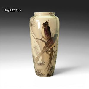 Pode incluir: Um vaso alto, creme, com um desenho pintado de dois pássaros empoleirados num galho. Os pássaros têm plumagem castanha e roxa. O vaso tem 25,7 cm de altura e apresenta um padrão botânico detalhado.