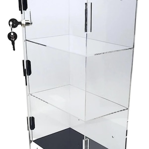 May include: A clear acrylic display case with two shelves and a black base. The case has a lock and key and the door is open.