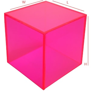 May include: A vibrant, transparent, hot pink cube. The edges and corners are sharply defined, creating a geometric shape. The cube is a solid color and appears to be made of a translucent material. The dimensions are not visible.