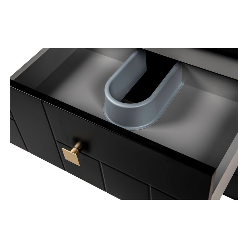 May include: A black drawer with a gold handle is open, revealing a grey plastic drawer organiser. The drawer has a textured, tile-like pattern.