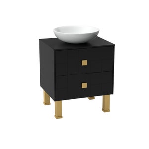 May include: Black bathroom vanity with two drawers and gold hardware. The vanity has a white ceramic sink on top and gold legs.