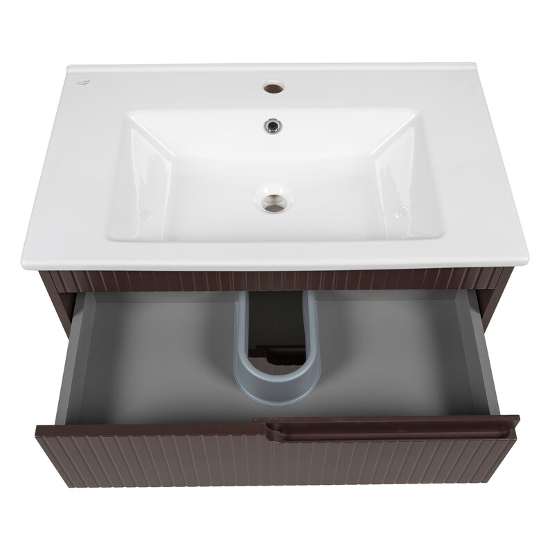 May include: A white ceramic bathroom sink with a single faucet and a brown wooden cabinet with a drawer. The drawer is open and reveals a gray interior with a white plastic pipe.