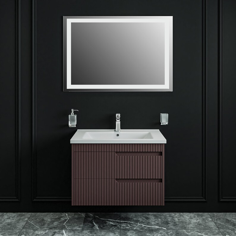 May include: A brown bathroom vanity with a white porcelain sink and a rectangular mirror with a white frame. The vanity has two drawers with vertical grooves and a chrome faucet.