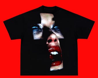 Camiseta extragrande con estampado de rostro abstracto, estilo gótico urbano, de tejido grueso y corte holgado en tonos oscuros.