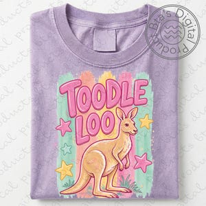 May include: A lilac-colored t-shirt featuring a kangaroo illustration with the words "TOODLE LOO" in pink bubble letters. The design includes colorful vertical stripes and star accents, creating a playful and whimsical aesthetic.