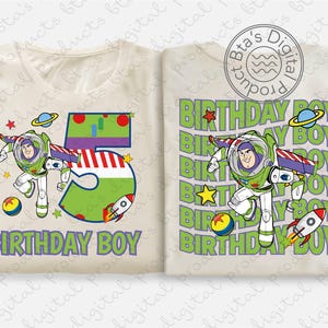 May include: Two cream-colored t-shirts with a Buzz Lightyear graphic. One shirt features a large number 5 with a rocket ship and the text "BIRTHDAY BOY." The other shirt has a repeating "BIRTHDAY BOY" and Buzz Lightyear design.