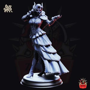 May include: A grey figurine of a woman in a layered dress and mask, holding a mask. The figure is on a round base, with the Zikgeek logo visible. The overall theme is fantasy or cosplay.