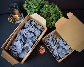May include: Two open cardboard boxes filled with unpainted gray plastic miniature figures. The boxes are on a black surface.