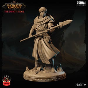 Può includere: Una statuetta in miniatura dettagliata di un guerriero con un turbante e una lancia. La statuetta è dipinta di un colore marrone chiaro e si trova su una base circolare. Il testo "Uncharted Kingdoms" e "The Mighty Stone" è visibile nella parte superiore dell'immagine. Il testo "PRIMAL COLLECTIBLES" è visibile nell'angolo in alto a destra dell'immagine. Il testo "Hakim" è visibile nell'angolo in basso a destra dell'immagine.