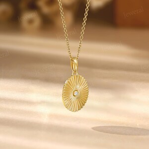 a gold necklace with a diamond in the center