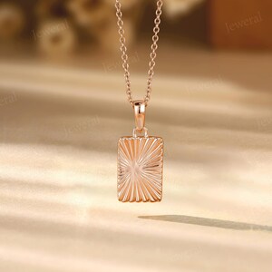 a gold necklace with a square shaped pendant