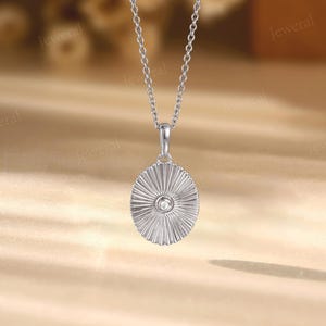 a silver necklace with a diamond in the center