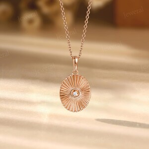 a gold necklace with a diamond in the center