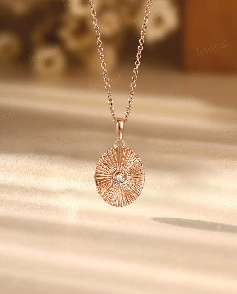 a gold necklace with a diamond in the center