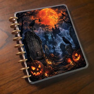 May include: A disc-bound notebook featuring a Halloween-themed cover illustration of a graveyard at night. The scene includes a large orange moon, glowing jack-o'-lanterns, translucent ghosts, black ravens, and a tombstone inscribed with Rest in Darkness.
