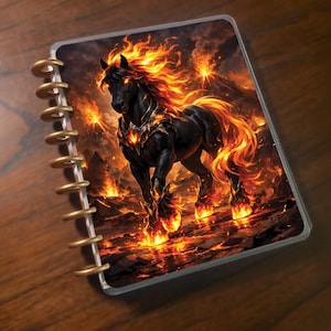 May include: A planner featuring a fantasy illustration of a black horse with fiery mane and hooves, set against a volcanic landscape. The planner has gold-colored binding rings and a clear protective cover.